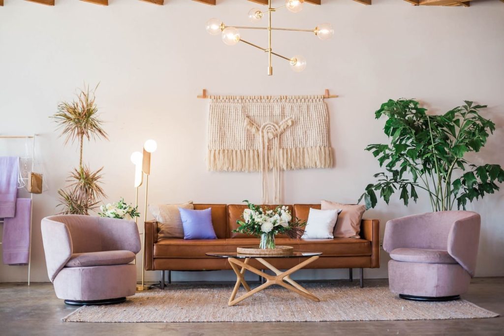 nice living room with lights, pot plant, coffee table and pink furniture