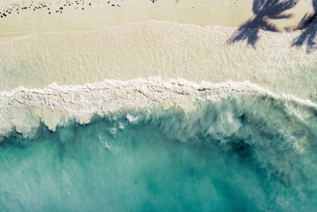 Overhead view of a beach in Zanzibar, with Arabic words in Swahili spoken in the local language